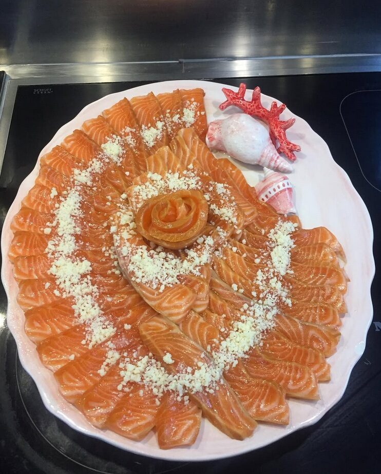 Orange-coloured slices arranged in circles on a round white plate.